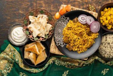 A beautifully plated Arabic feast featuring Kabsa with tender meat, golden rice, crispy samosas, creamy hummus, and pita bread, showcasing Middle Eastern flavors in Nepal.